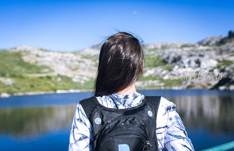 背着背包的年轻女子徒步旅行者在户外的山区旅行