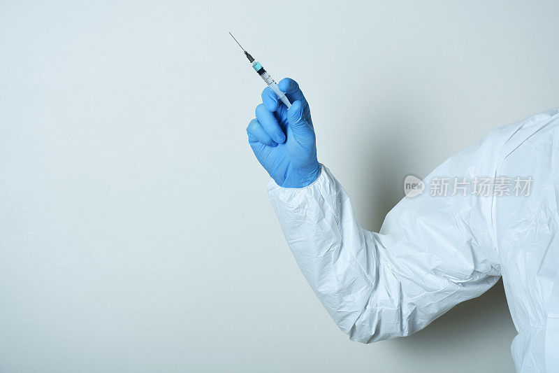 医生或护士手持医用注射针筒注射疫苗