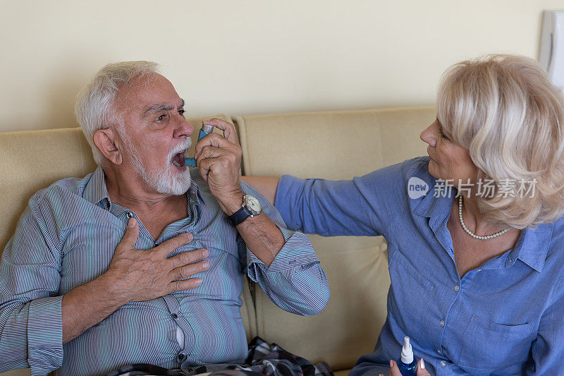 一对老年夫妇正在解决一个使用吸入器的老人的呼吸问题。