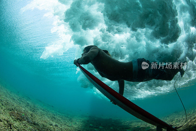 冲浪者在海浪下潜水的特写