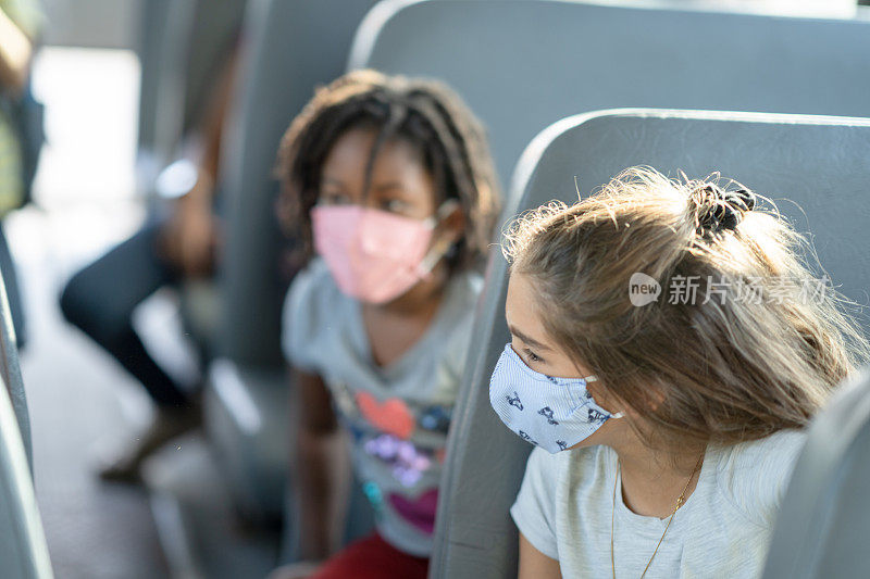 白人小学女生在校车上和朋友聊天