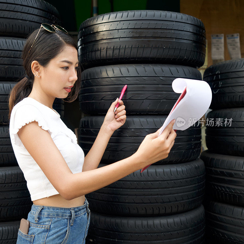 早上上班前，汽车配件店的年轻亚洲老板会检查轮胎的数量和收到的订单。几条汽车轮胎在轮胎店里排列着。