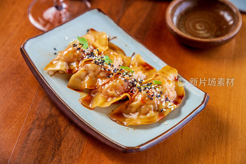 食用大小的日式煎饺或蘸酱油的饺子放在长方形的盘子里