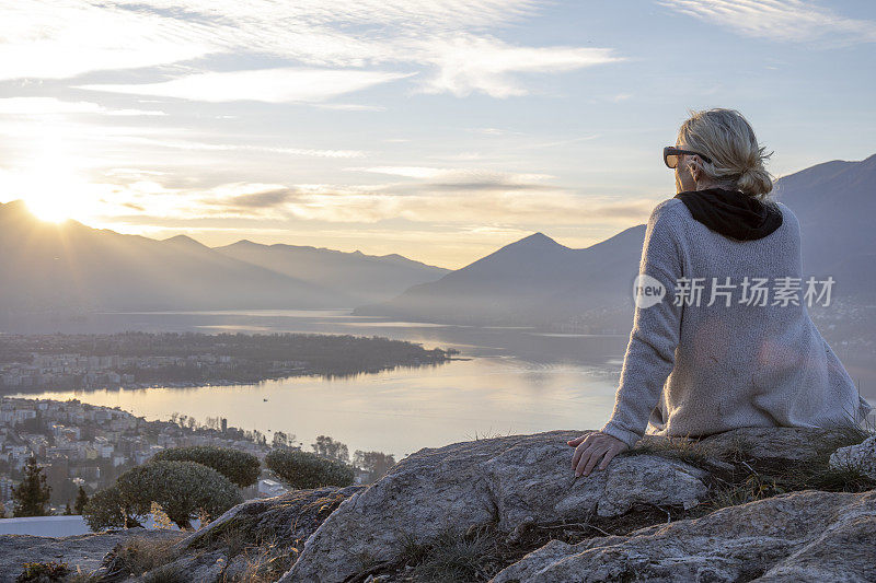 日出时分，女徒步旅行者在山脊上休息