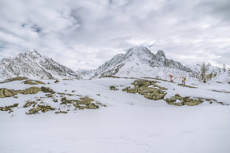 徒步旅行者沿着雪山中的山脊行进