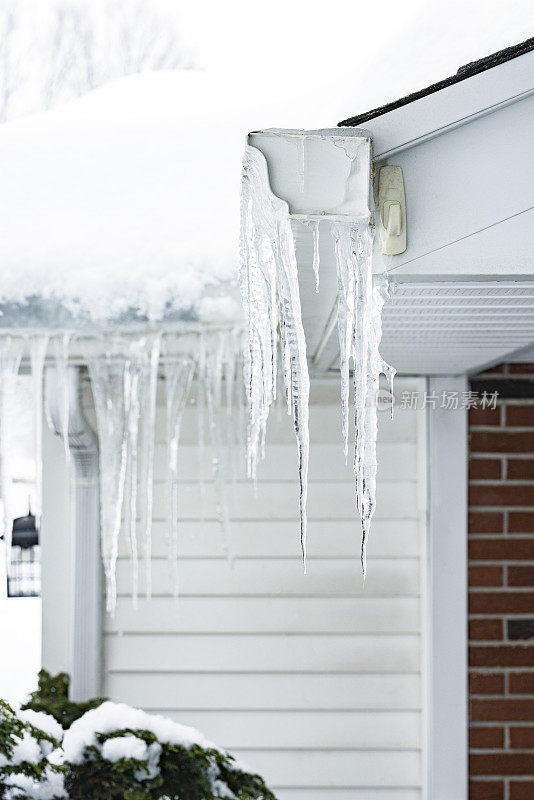 悬挂在屋顶排水沟尽头的冬季冰柱