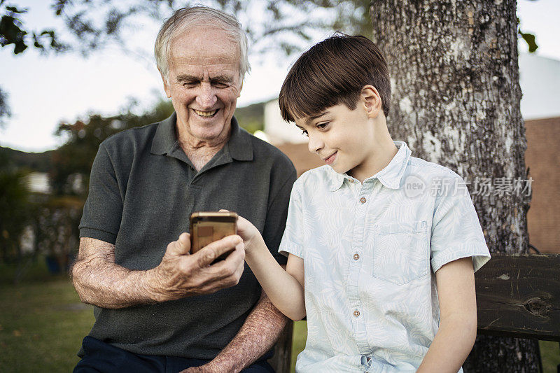 孙子教爷爷如何使用智能手机。