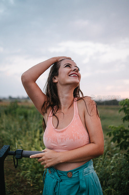 手握电动摩托车车把的女人在雨中享受