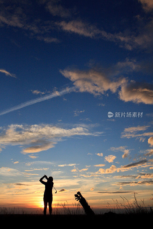 女性高尔夫球剪影与戏剧性的日落天空