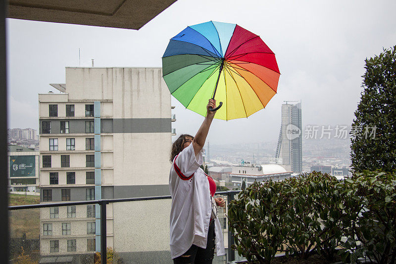 雨点落在彩虹伞上，天以自然为背景