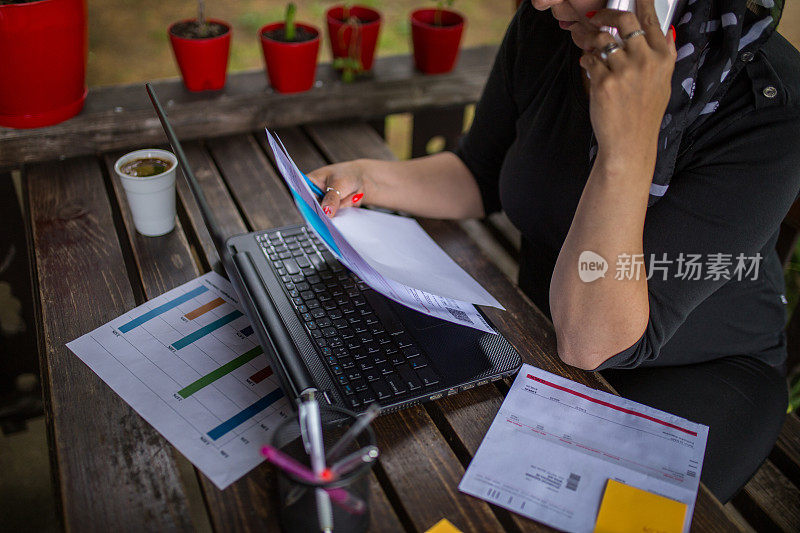 女人在家里使用电话并做笔记