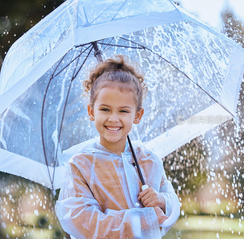 一个小女孩拿着伞在雨中嬉戏