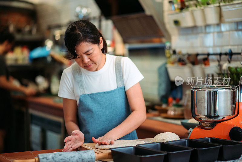 亚洲华人面包师在厨房准备生面团