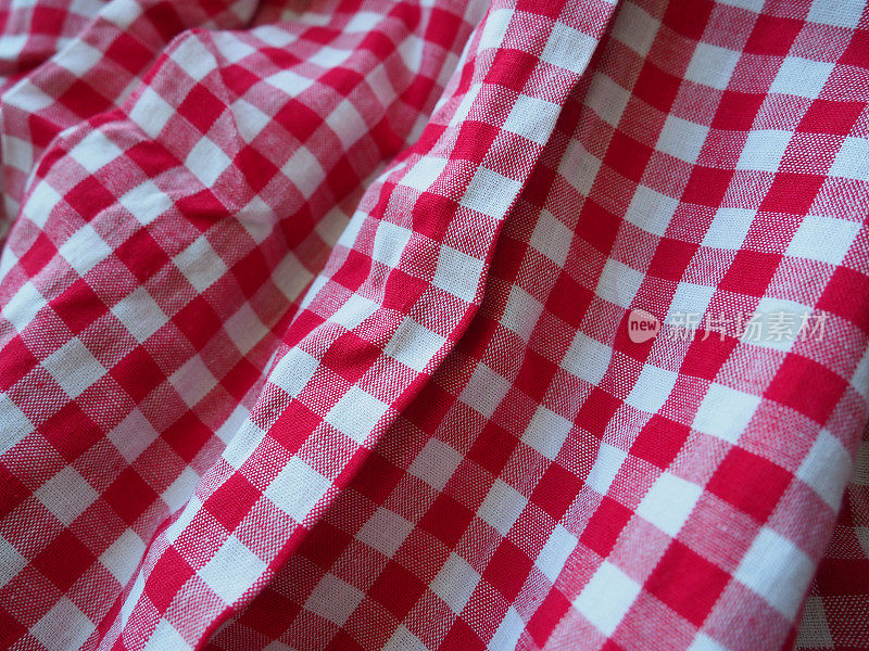 红色和白色的格子背景与条纹广场野餐毯，台布，格子，衬衫和纺织品。面料质地。红白两色方框棉布，皱折成波浪状。