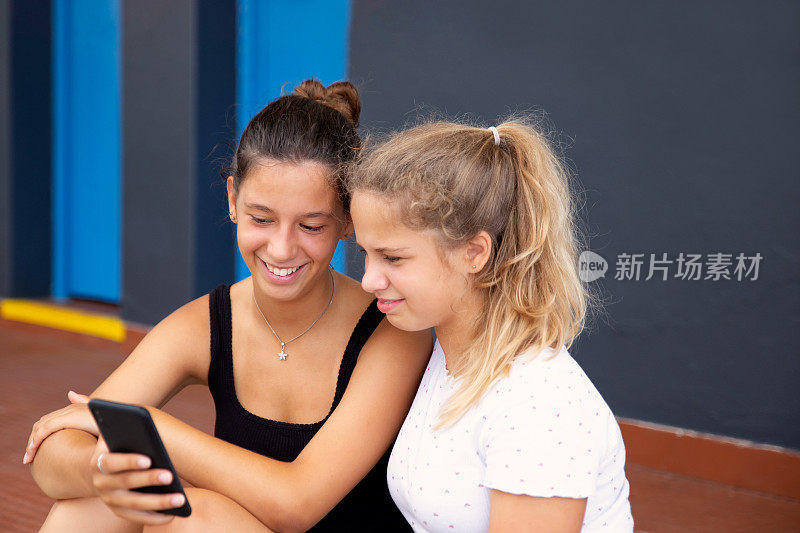两个十几岁的女孩在看手机视频