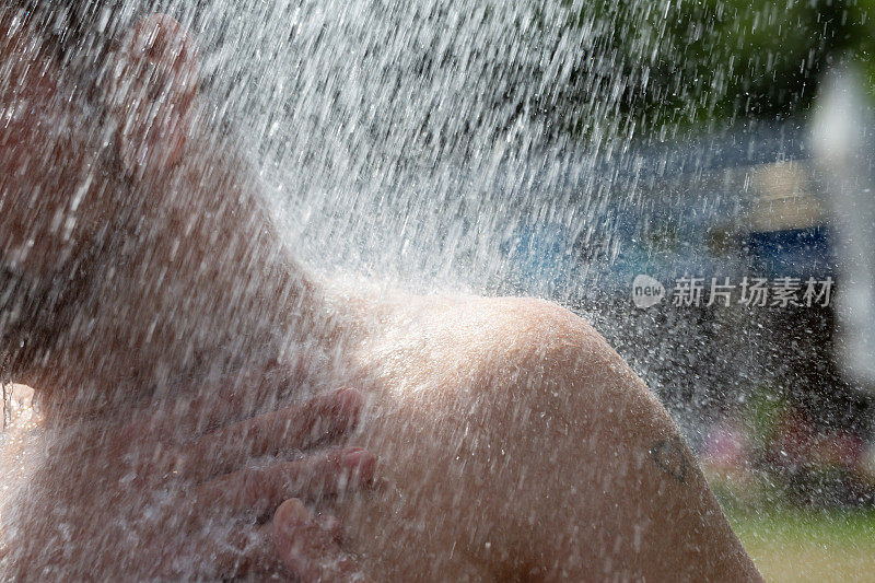 特写:一个夏天在户外洗澡的男人的肩膀