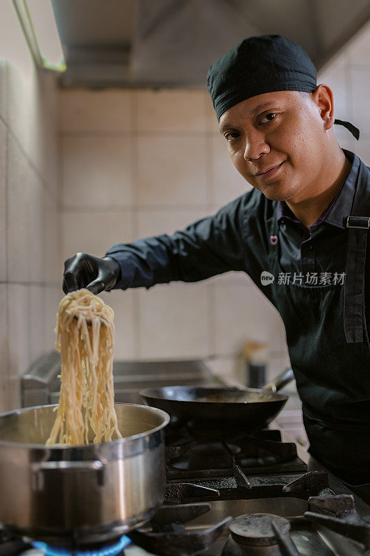 一个穿黑色制服的厨师正在准备饭菜。