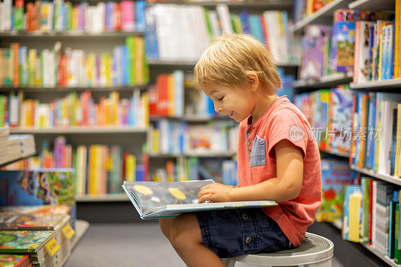 可爱的学龄前儿童，夏日在书店里看书