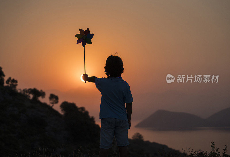 后视图的男孩拿着一个玩具风车