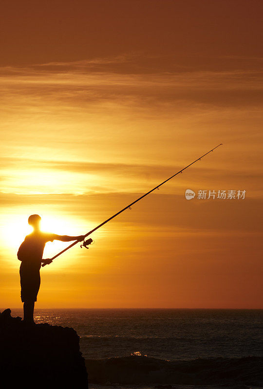 男孩在夕阳下出海捕鱼