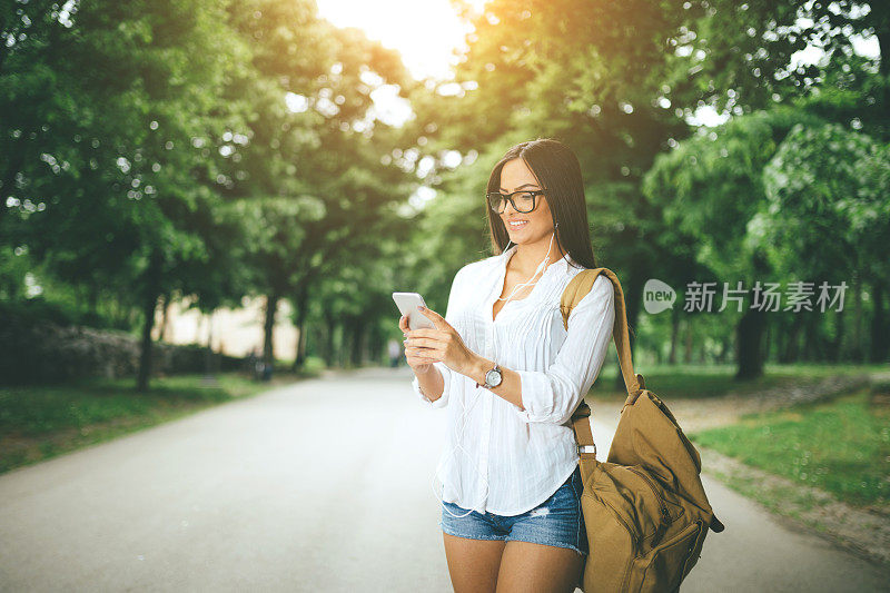 美丽的女人在户外使用智能手机