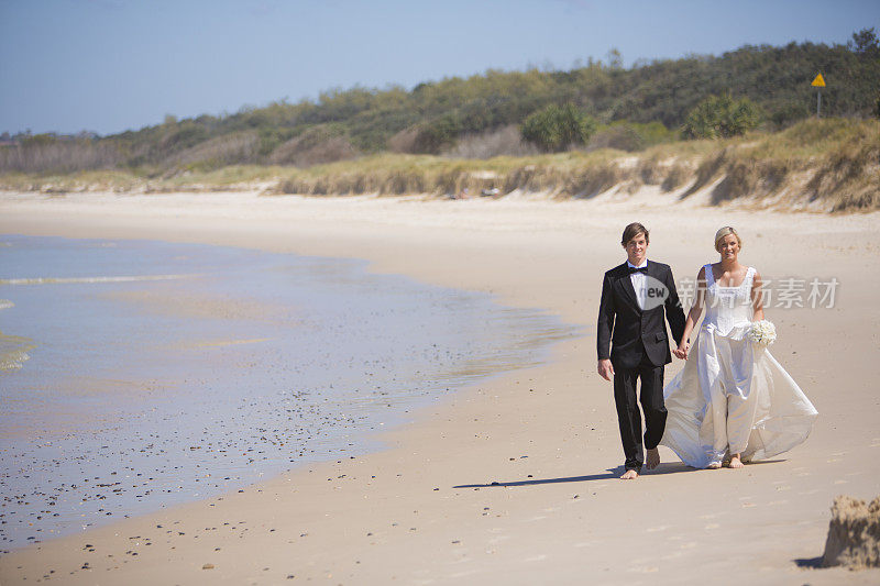 一对新婚夫妇在海滩上散步