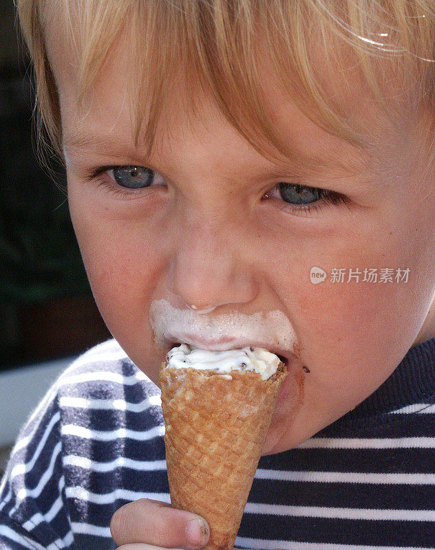 男孩吃蛋筒冰淇淋的特写