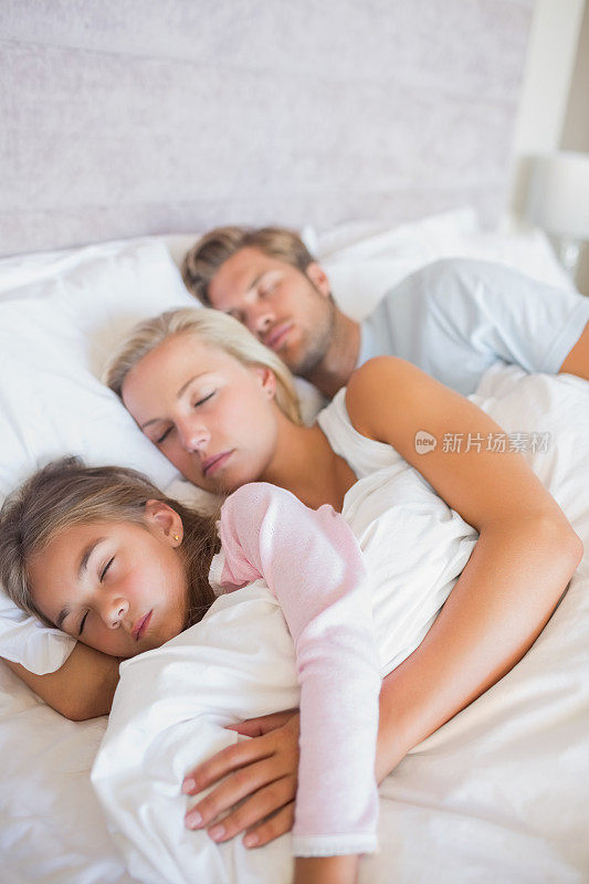 女孩和父母一起睡在床上