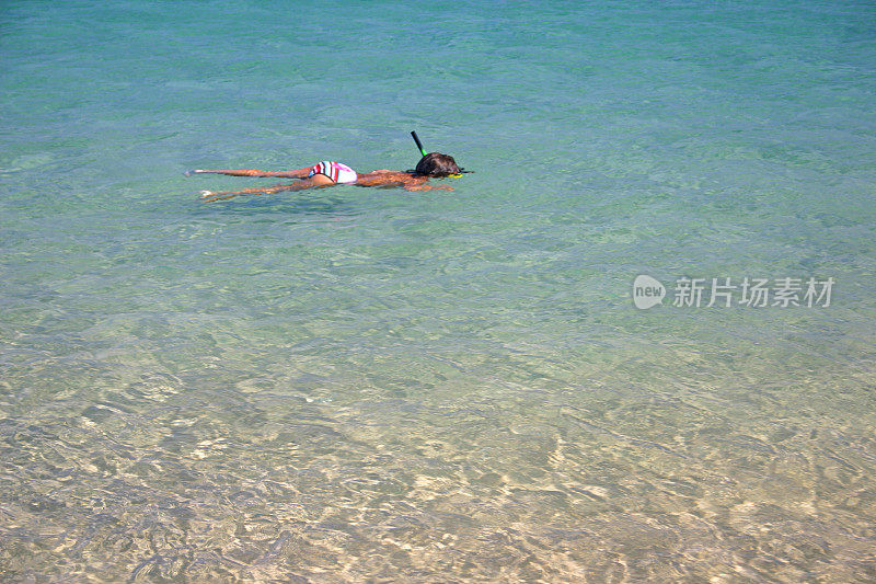 年轻女孩在海滩上潜水