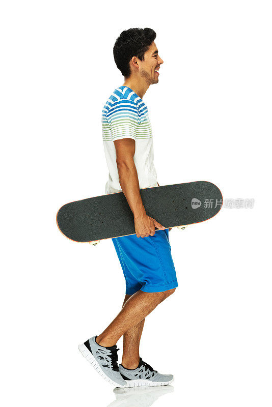微笑的男人走着，拿着滑板