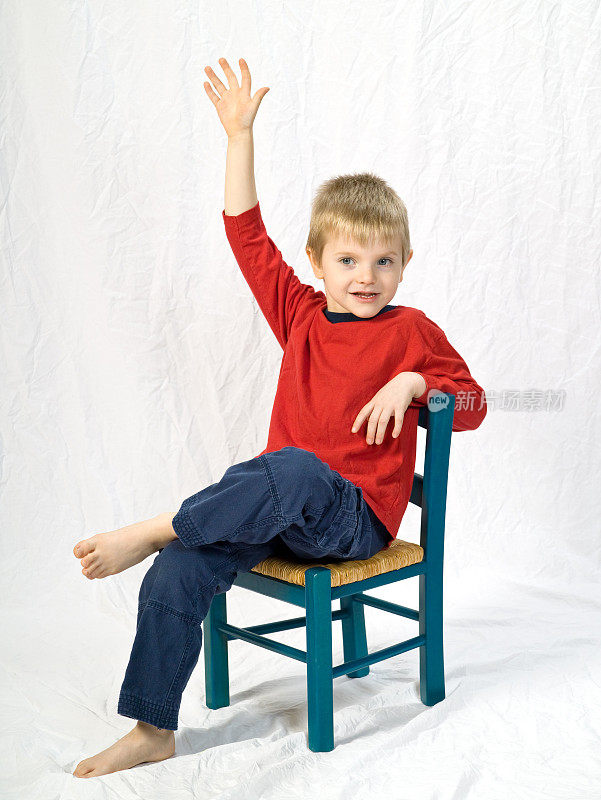 小男孩在椅子上举起手来