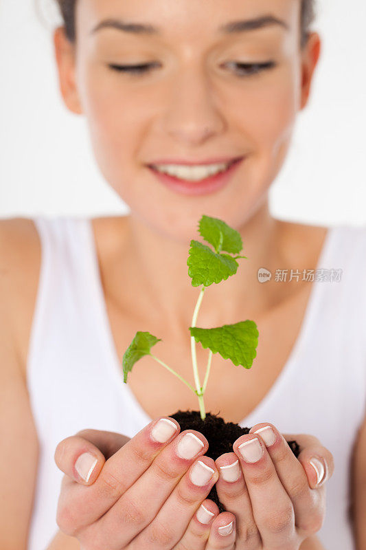 美丽的年轻女子与小植物