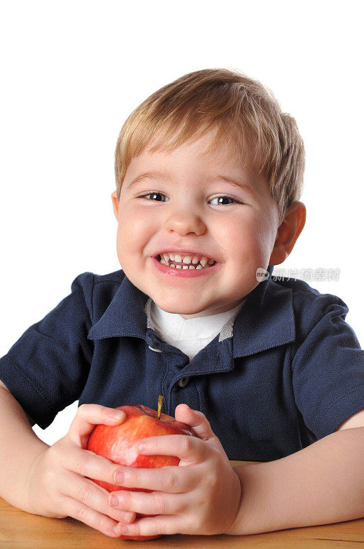 快乐的小男孩吃一个大的红苹果小吃
