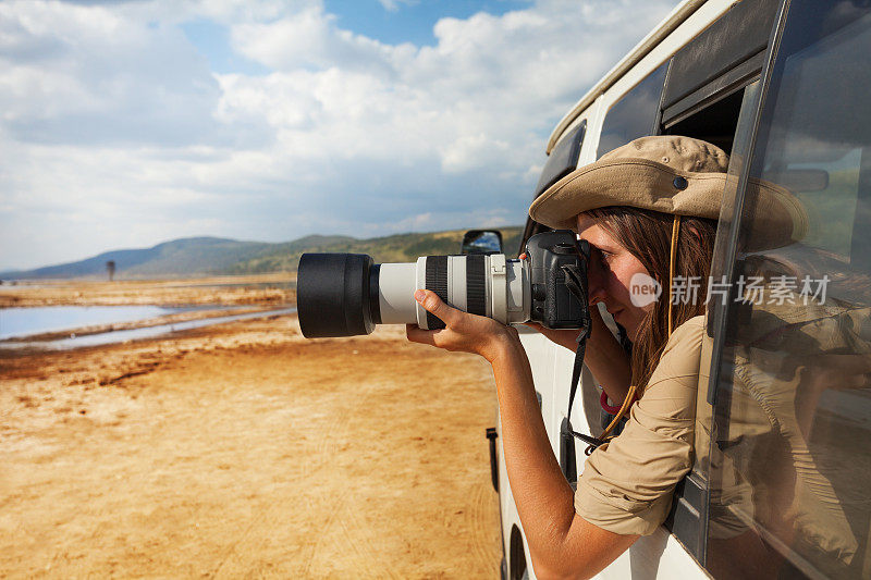 女孩在吉普车上拍摄非洲大草原