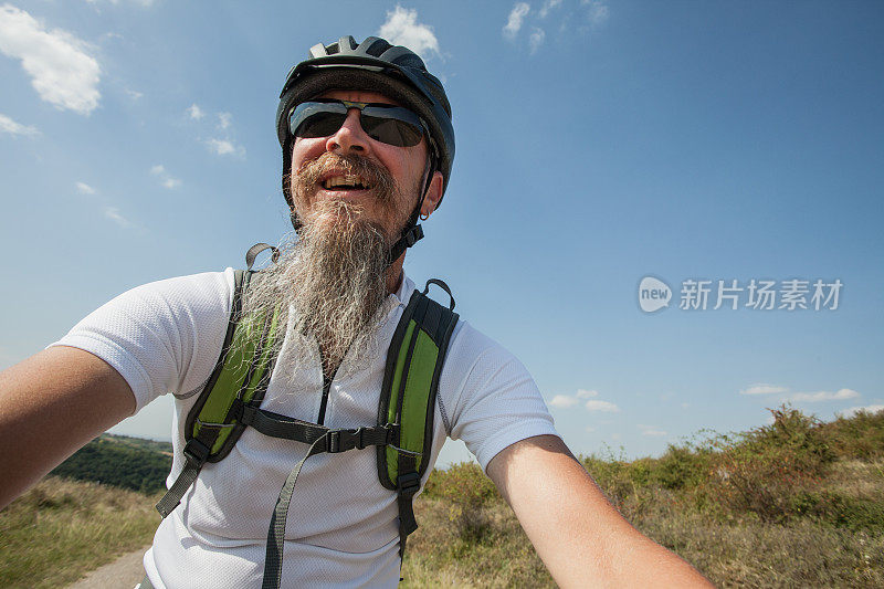 一个留着长胡子的男人在骑山地车