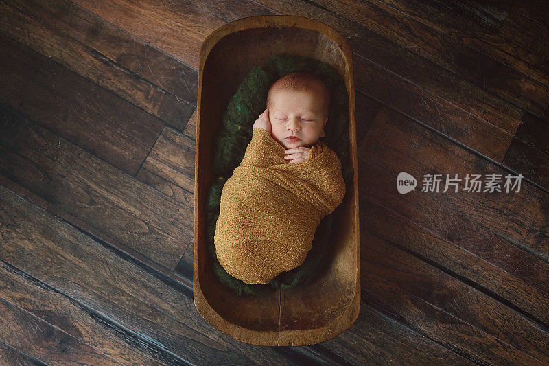 新生儿睡在古董木碗里