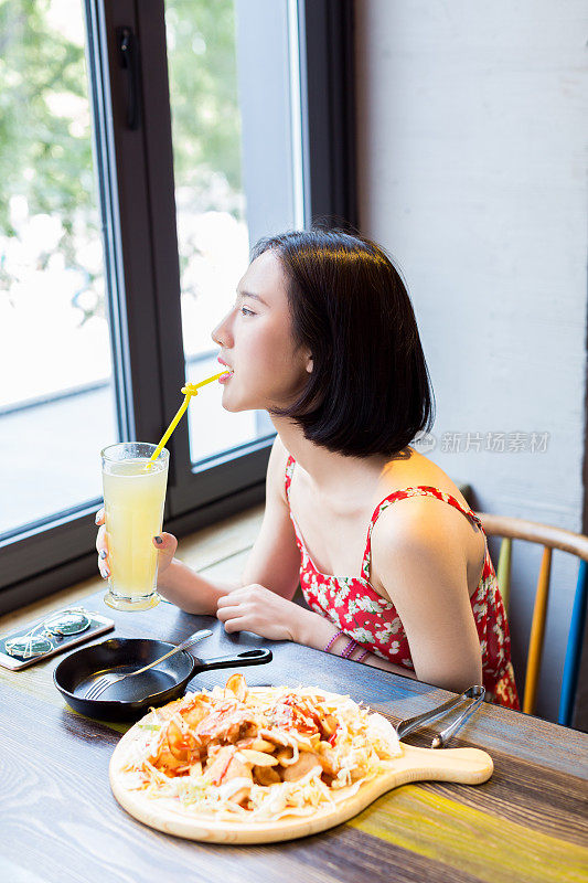 一位年轻的中国妇女正在餐馆吃午饭