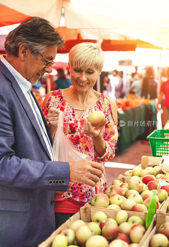 一对成熟的夫妇在街头市场上买食物