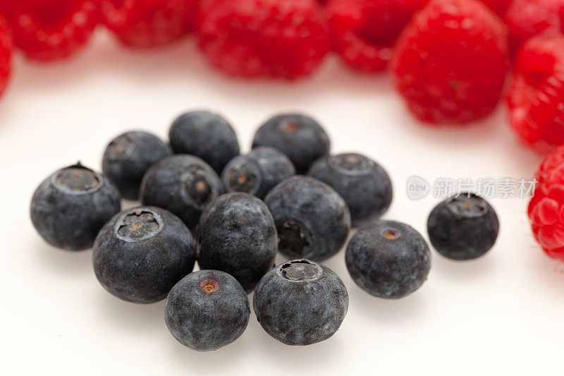 微距蓝莓在普通背景与覆盆子