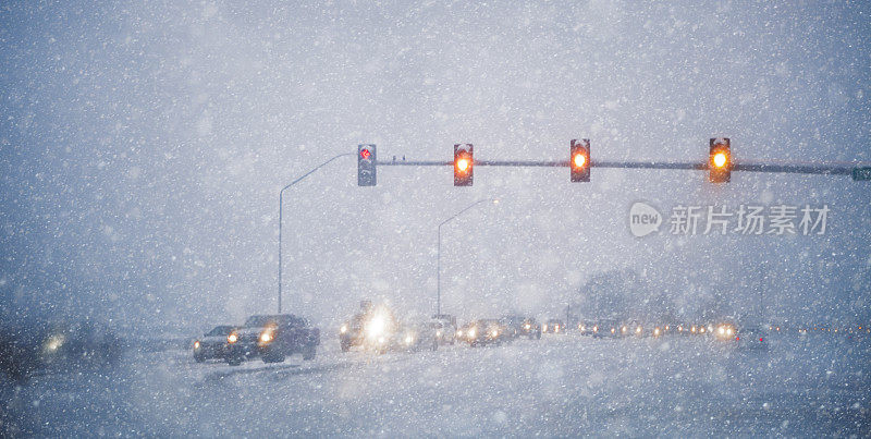 在冬季暴风雪中，交通缓慢地通过一个十字路口