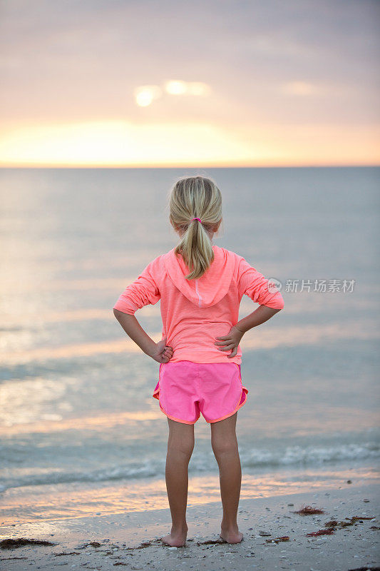 看着海洋海滩日落的小女孩