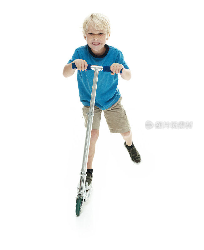 微笑的小男孩骑着滑板车