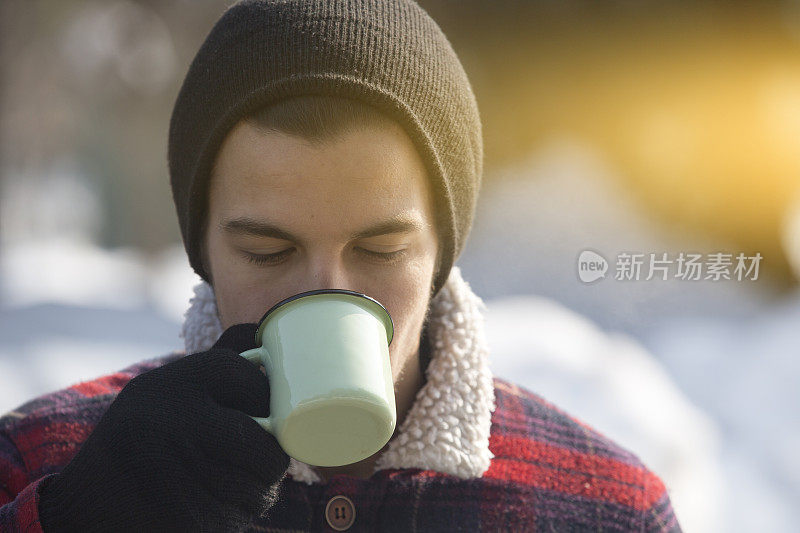 男人在山上拿着一杯热茶