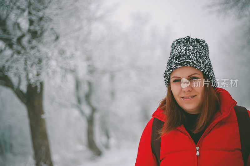 女徒步旅行者背包和雪鞋在雪地上的雪鞋