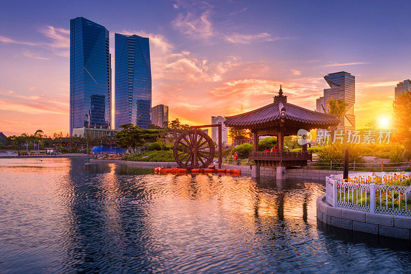 韩国仁川松岛国际商务区中央公园，日落中的汉城传统与现代建筑。