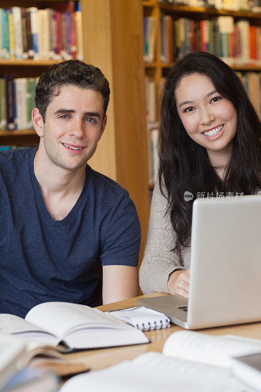 两个学生在图书馆用笔记本电脑学习