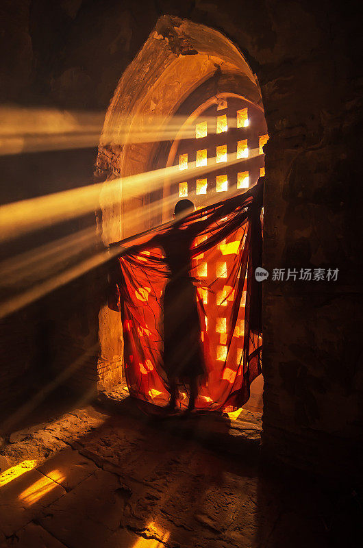 缅甸曼德勒蒲甘宝塔中僧人用阳光换僧袍的背影