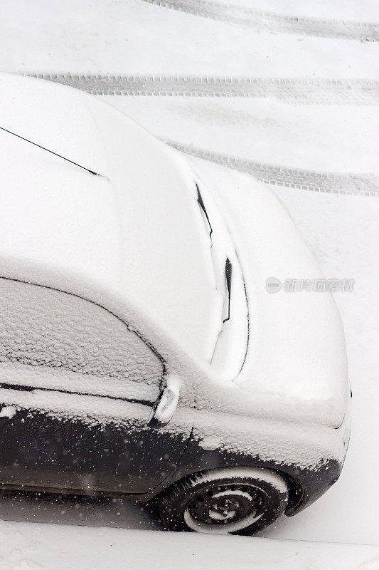 在暴风雪中，汽车前部被雪覆盖的碎片