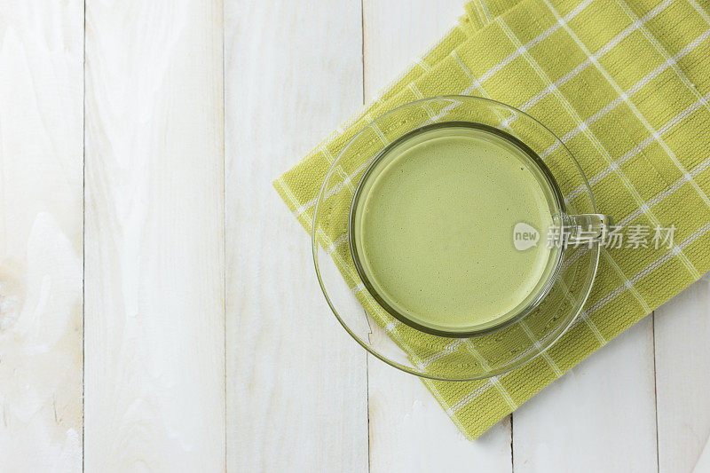 顶视图绿茶玻璃上的白木背景。绿茶对身体有益，抗氧化剂。