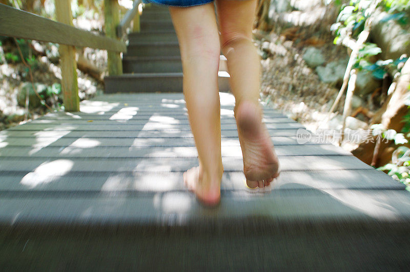 女孩跑上了户外的木台阶